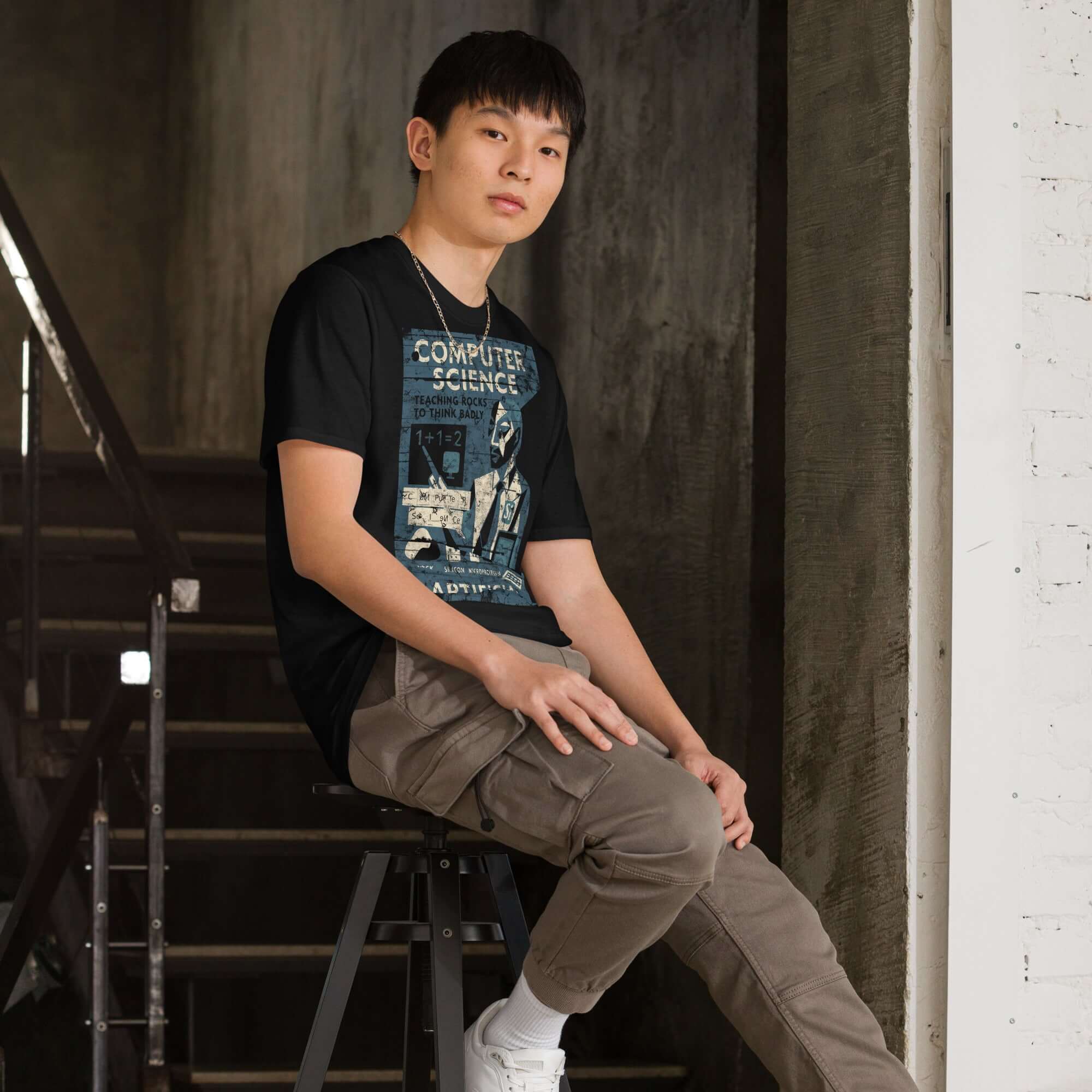 Person wearing "Teaching Rocks to Think Badly" Computer Science T-Shirt, featuring a vintage educational poster design.