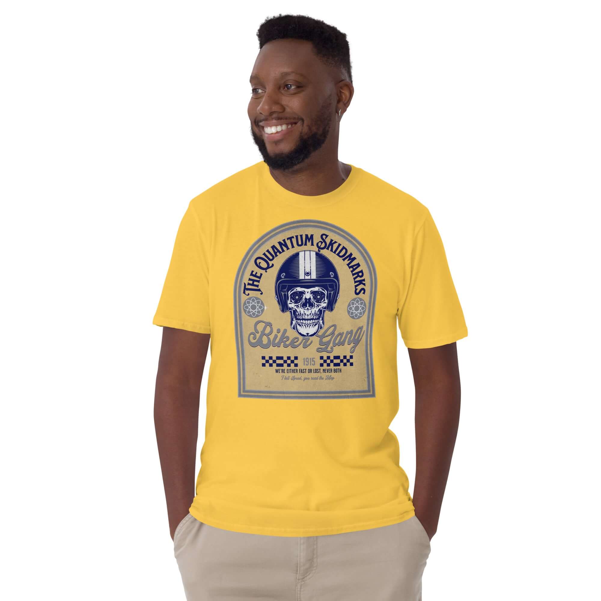 Man wearing yellow Quantum Skidmarks Motorcycle Club T-Shirt with a skull design, celebrating physics-inspired biker gang theme.
