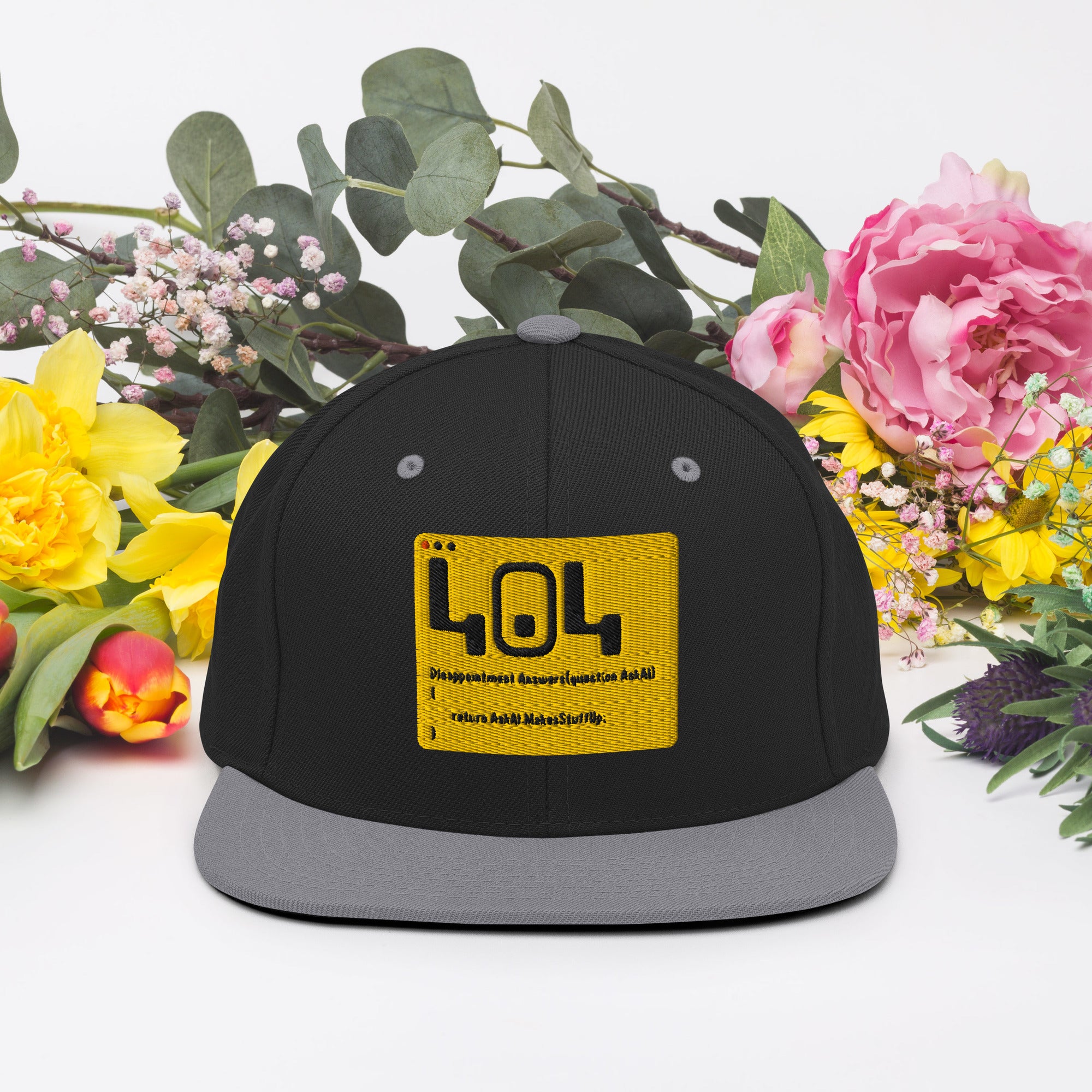 Alt Tag: 404 Disappointment Hat Snapback with developer humor amidst colorful flowers, perfect for tech enthusiasts.