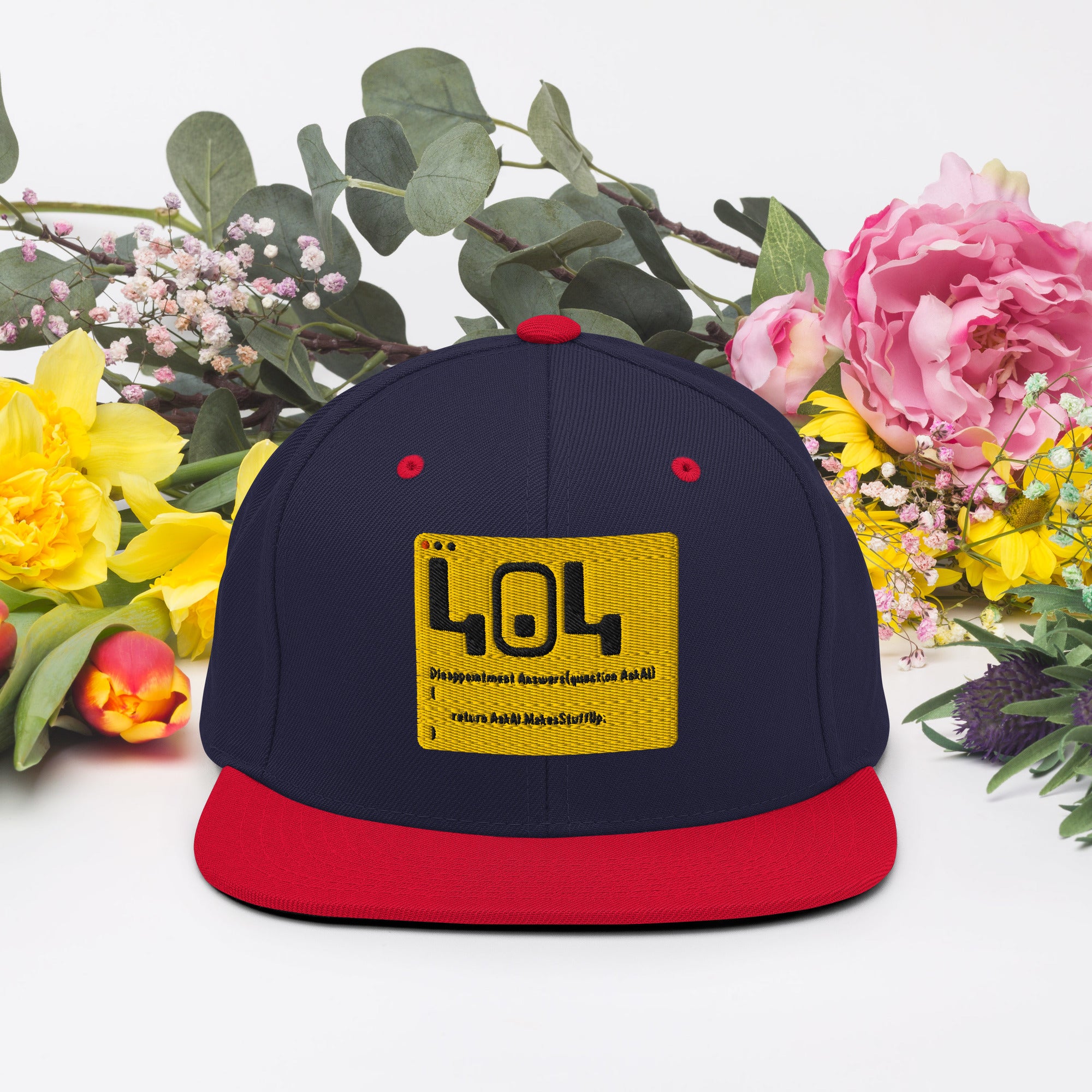 Navy and red snapback hat with '404 Disappointment' patch, surrounded by colorful flowers, combining tech humor with fashion.