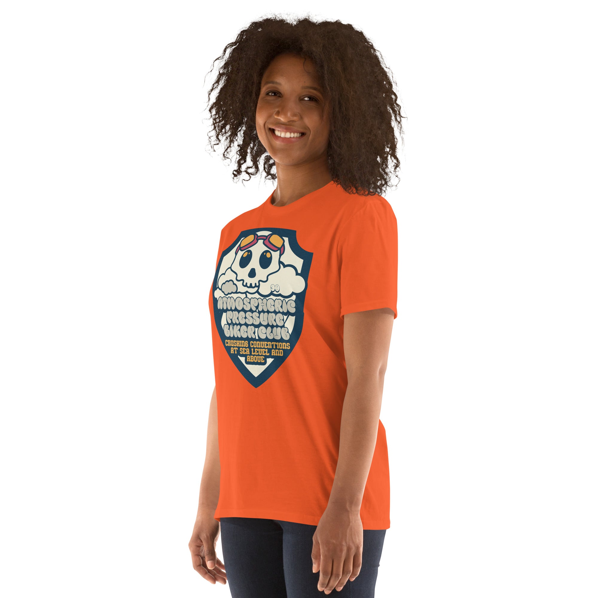Woman wearing orange Atmospheric Pressure Biker Club t-shirt with cute skull and cloud design, perfect for meteorological motorcycle fans.