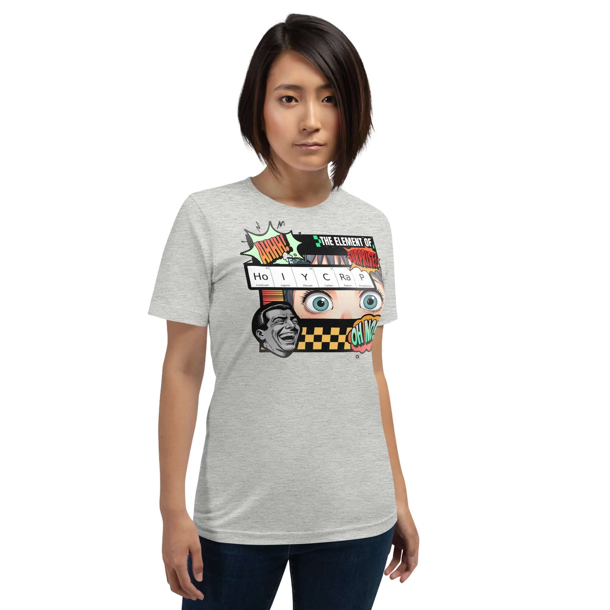 Woman wearing a HoIYCRaP Chemistry Joke T-Shirt featuring the Element of Surprise with retro comic book design on a gray background.