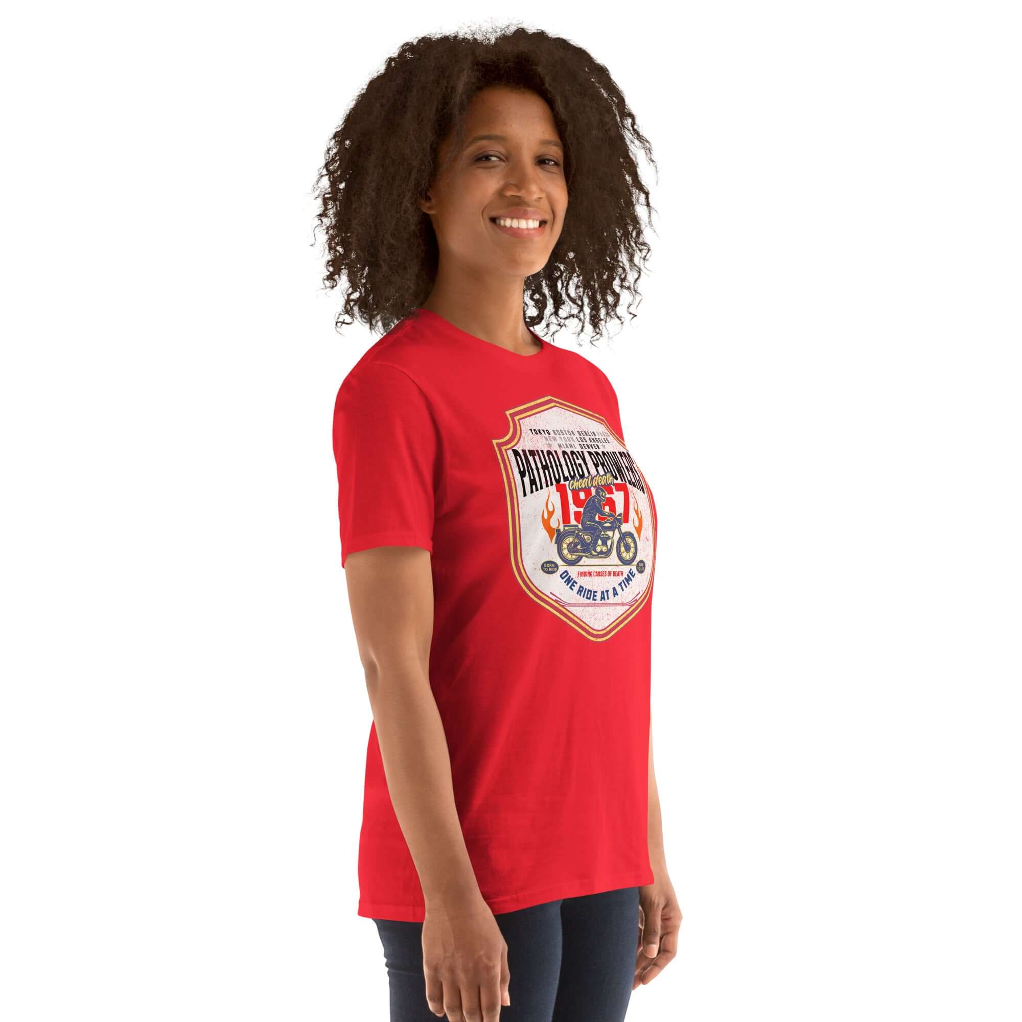 Person wearing a red Pathology Prowlers MC T-Shirt, featuring a vintage shield emblem with motorcycle design.