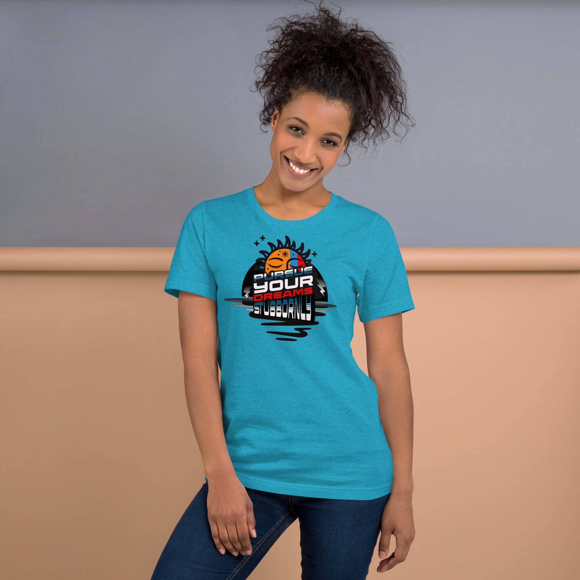 Smiling woman wearing a blue 'Pursue Your Dreams Stubbornly' t-shirt by Cosmic Motivation Apparel with a cosmic design.