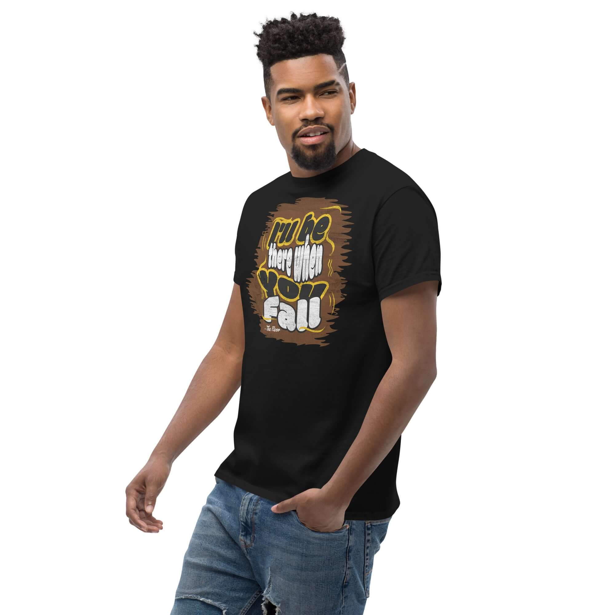 Man wearing 'I'll Be There When You Fall' black t-shirt, reflecting ironic apparel with a humorous floor support theme.